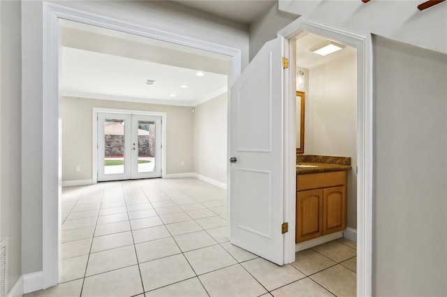 corridor with light tile patterned flooring, french doors, and crown molding