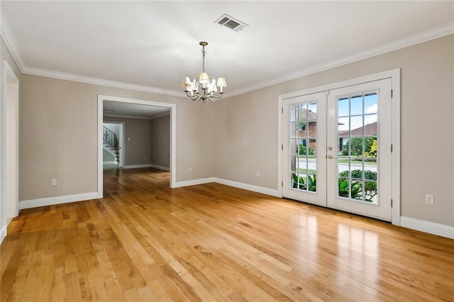 unfurnished room featuring crown molding, french doors, light hardwood / wood-style flooring, and a chandelier