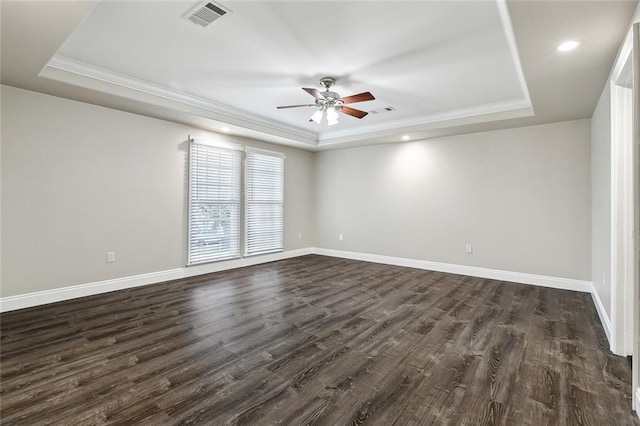 spare room featuring ceiling fan, a tray ceiling, and dark hardwood / wood-style flooring