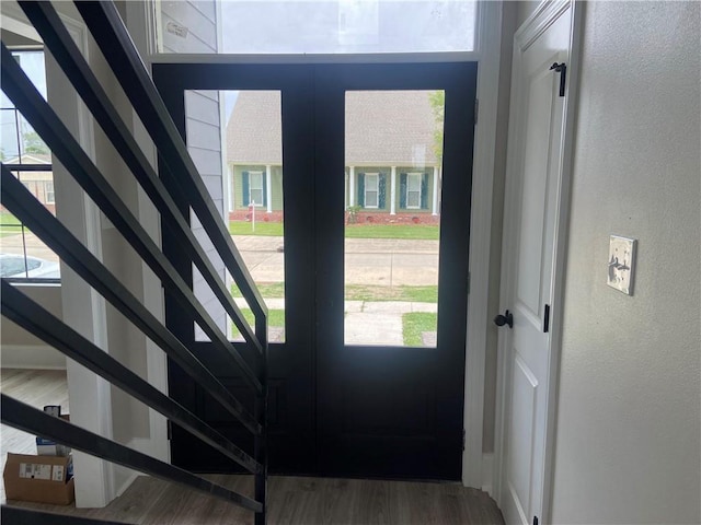 entrance foyer featuring wood finished floors, stairway, and a textured wall