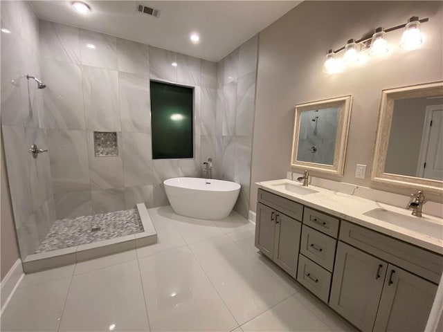 full bathroom featuring a sink, visible vents, tiled shower, and a freestanding tub