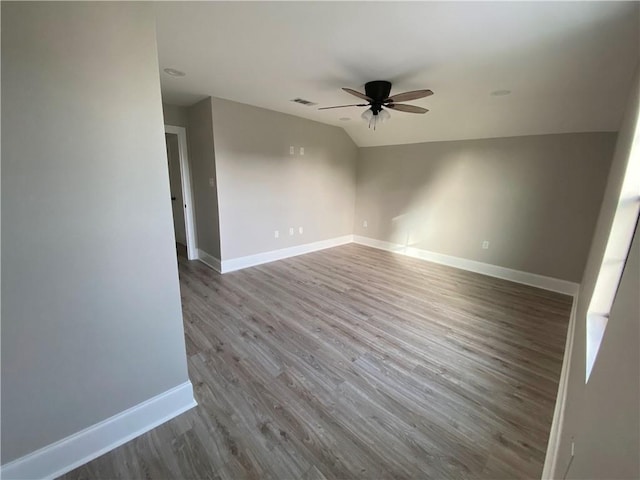 unfurnished room featuring vaulted ceiling, baseboards, ceiling fan, and wood finished floors