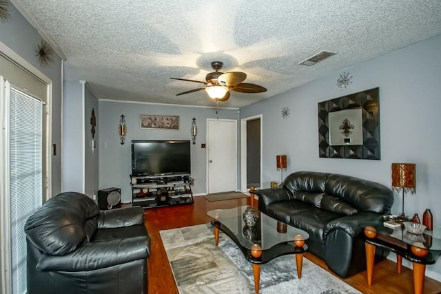 living room with a textured ceiling and ceiling fan