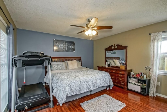 bedroom with ceiling fan, dark hardwood / wood-style floors, and a textured ceiling