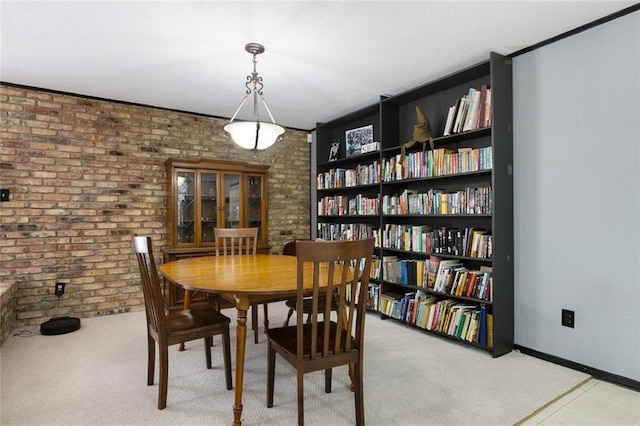 carpeted dining room with brick wall