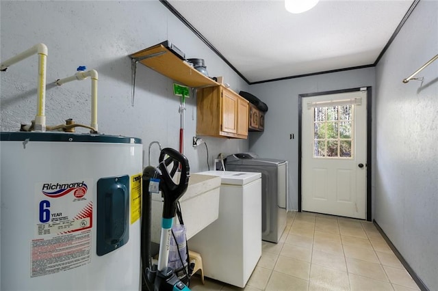 clothes washing area featuring crown molding, water heater, washing machine and clothes dryer, and light tile patterned floors