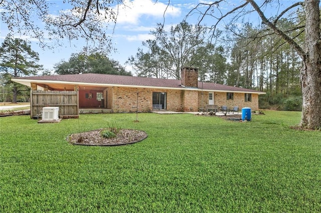 rear view of property featuring a yard, central air condition unit, and a patio area