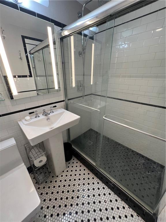 1205 St Charles Ave Unit 1101, New Orleans, LA 70130 - bathroom featuring a shower stall, toilet, and tile patterned flooring