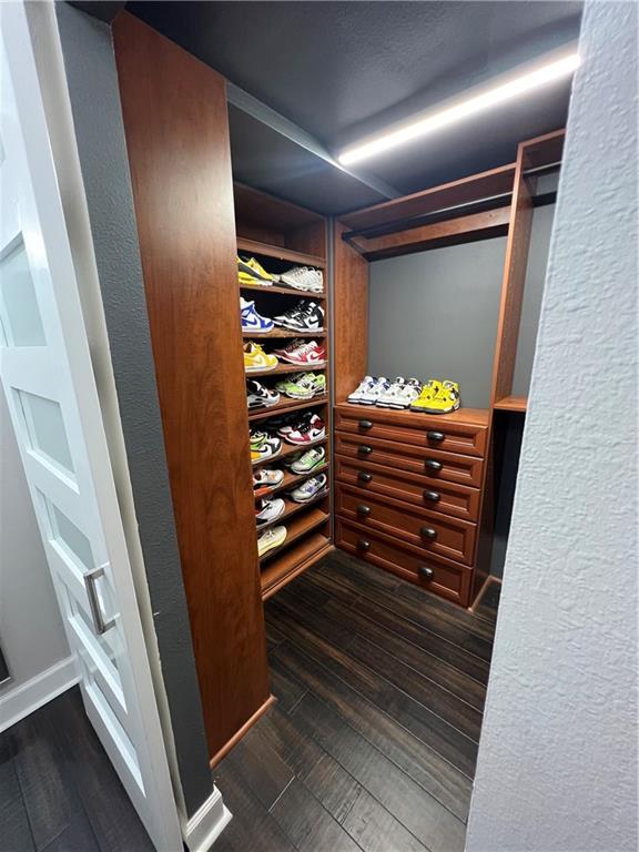 spacious closet with dark wood-type flooring