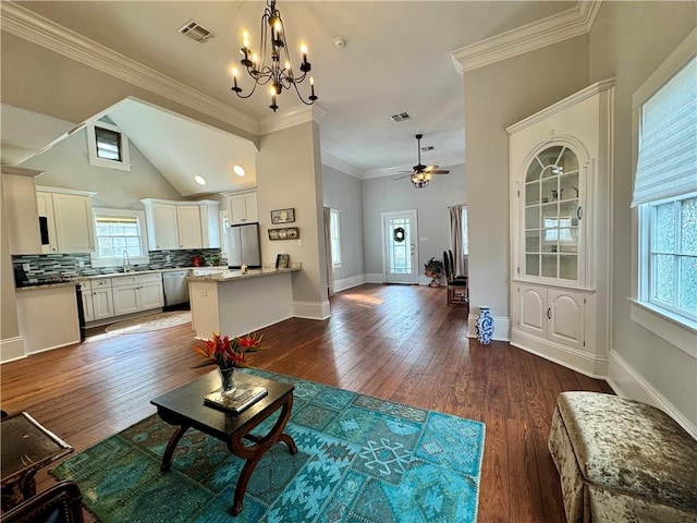 living room with crown molding, vaulted ceiling, dark wood-type flooring, and a wealth of natural light