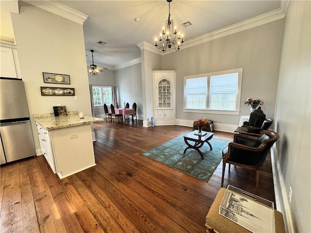 sitting room with dark wood-type flooring, ornamental molding, and ceiling fan with notable chandelier