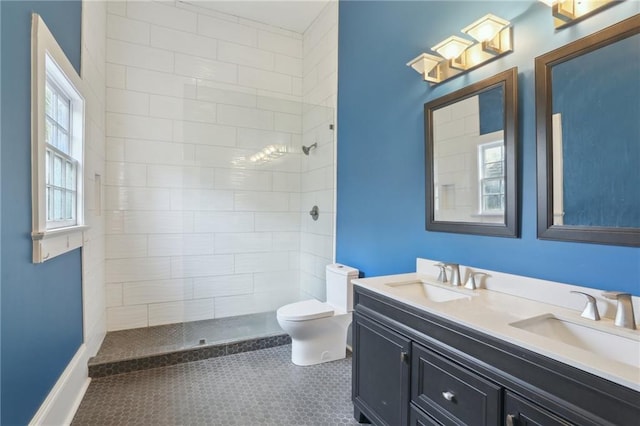 bathroom featuring tiled shower, vanity, toilet, and tile patterned flooring