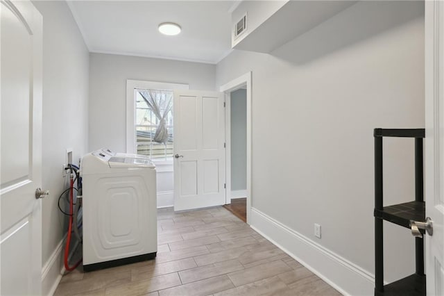 laundry area with washing machine and clothes dryer and ornamental molding