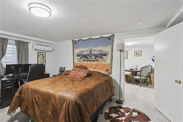 bedroom with an AC wall unit and a textured ceiling