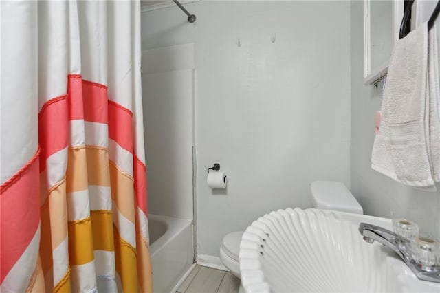 bathroom featuring shower / bath combo and toilet