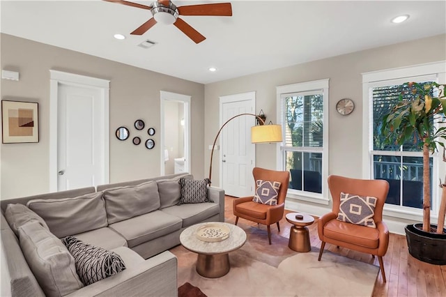 living room with wood-type flooring and ceiling fan