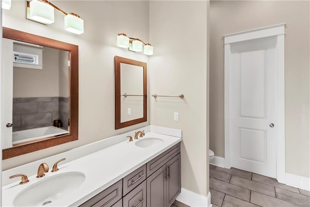 bathroom with vanity, tile patterned floors, a tub, and toilet