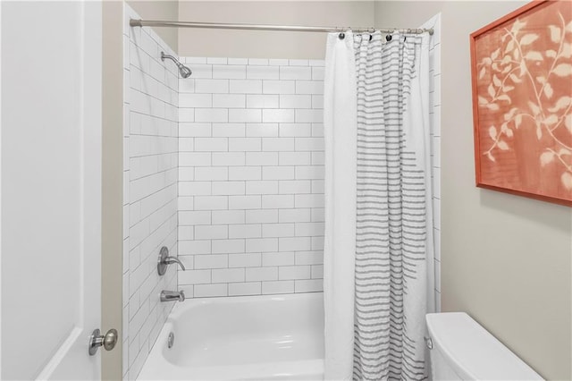 bathroom featuring shower / bath combination with curtain and toilet