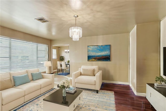 living room with dark hardwood / wood-style floors and a notable chandelier