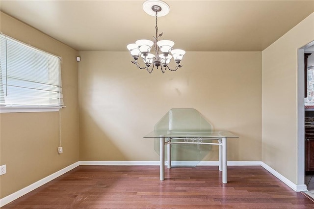 unfurnished dining area with an inviting chandelier and hardwood / wood-style floors