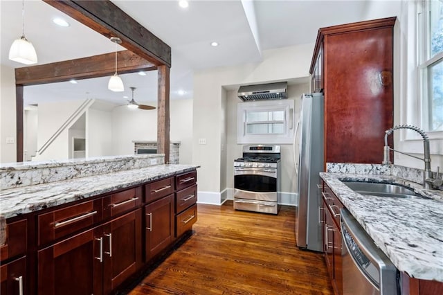 kitchen featuring beamed ceiling, appliances with stainless steel finishes, hanging light fixtures, and sink