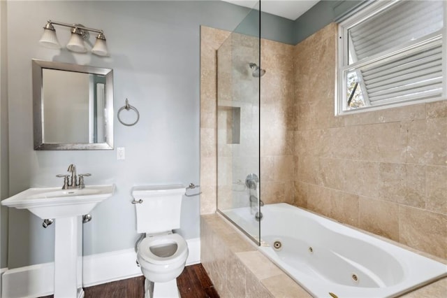 full bathroom featuring sink, tiled shower / bath, and toilet