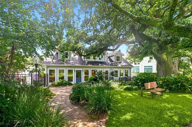 rear view of property featuring a lawn