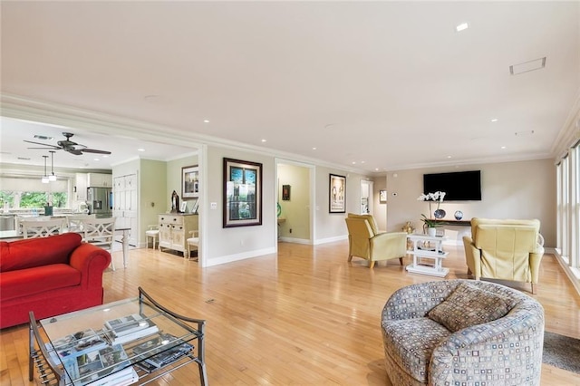 living room with ceiling fan, ornamental molding, and light hardwood / wood-style floors