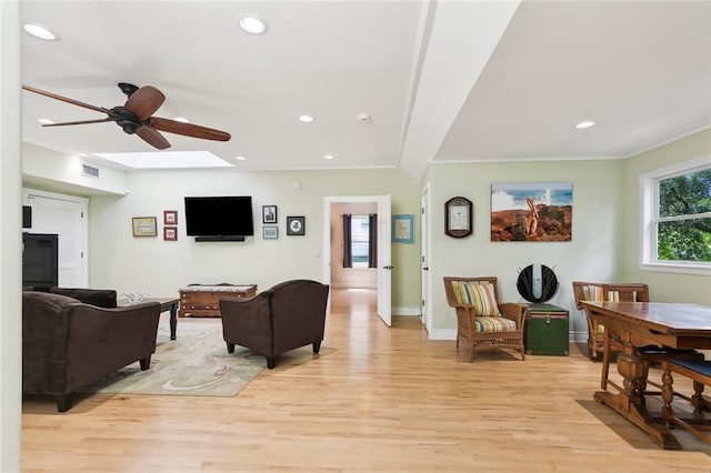 living room with ceiling fan, light hardwood / wood-style flooring, and ornamental molding