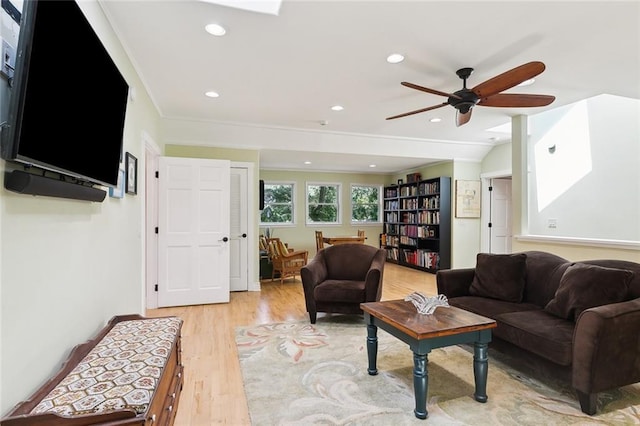 living room with light hardwood / wood-style floors, ceiling fan, and vaulted ceiling