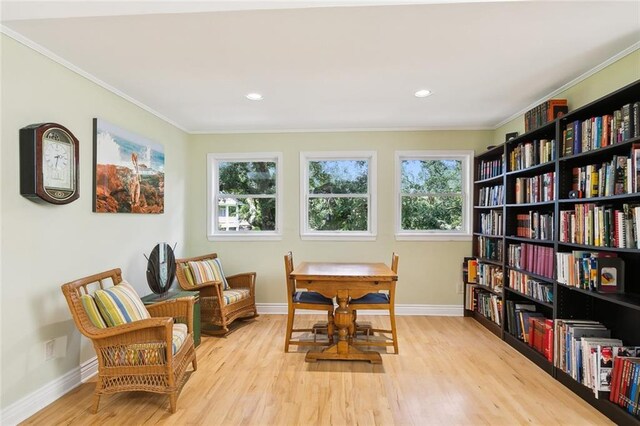 sitting room with crown molding and light hardwood / wood-style floors