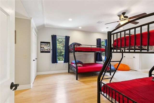 bedroom featuring vaulted ceiling, ceiling fan, ornamental molding, and hardwood / wood-style flooring