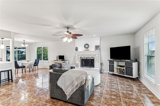 living room featuring ceiling fan with notable chandelier