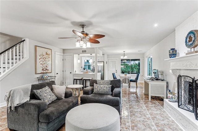 living room with ceiling fan and a fireplace