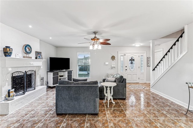 living room featuring ceiling fan and a fireplace