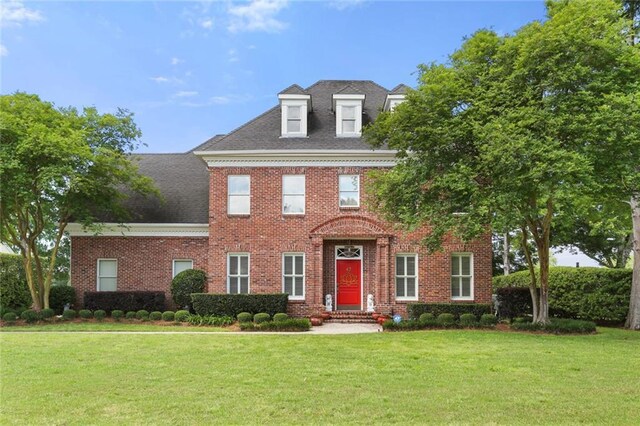 colonial home featuring a front lawn