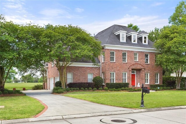 colonial-style house featuring a front yard and a garage