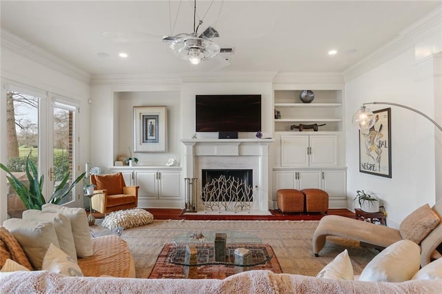 living room featuring crown molding, wood-type flooring, ceiling fan, and built in shelves