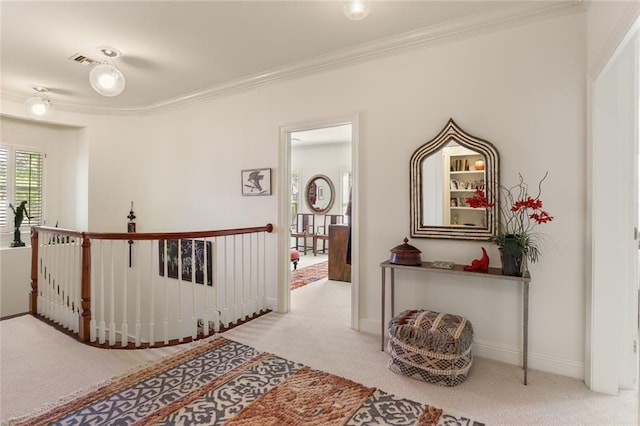 hallway with ornamental molding and carpet