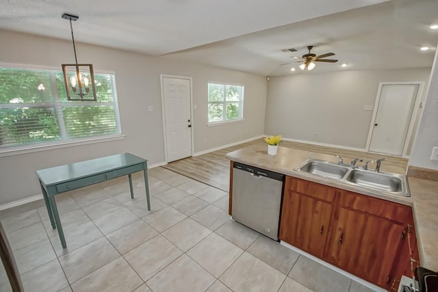 kitchen featuring sink, dishwasher, light tile patterned floors, ceiling fan with notable chandelier, and pendant lighting