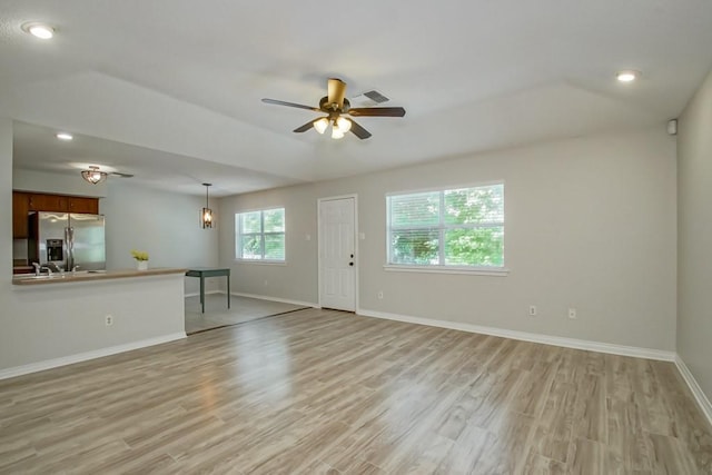 unfurnished living room featuring ceiling fan and light wood-type flooring