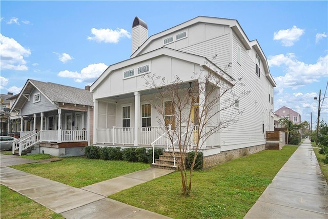 view of front of house with a front yard and covered porch