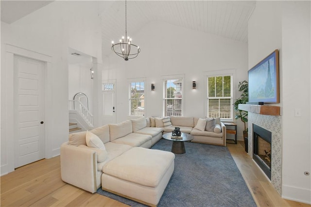 201 S Cortez St, New Orleans, LA 70119 - living area featuring light wood-style flooring, high vaulted ceiling, stairs, a tile fireplace, and a chandelier