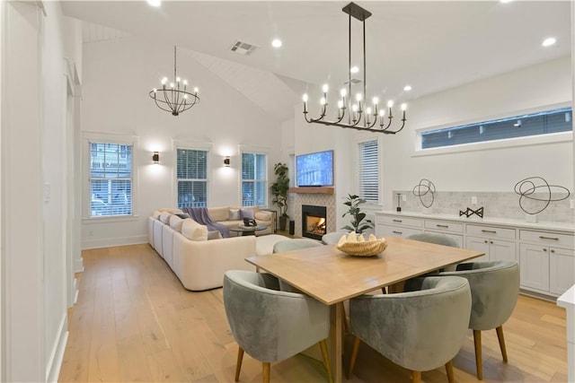 dining area featuring high vaulted ceiling and light wood-type flooring