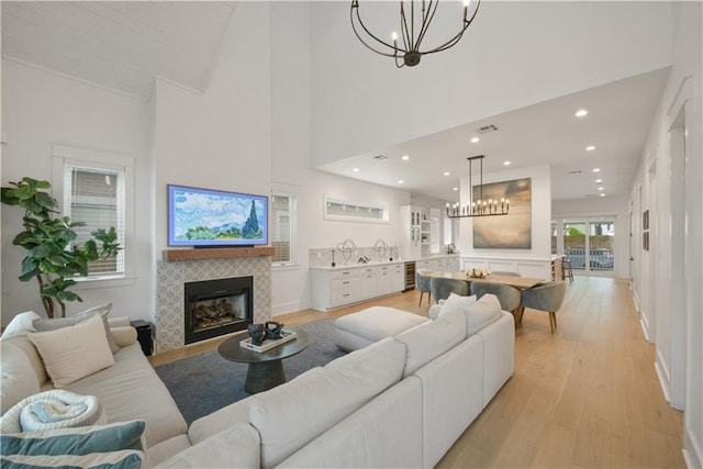 201 S Cortez St, New Orleans, LA 70119 - living area featuring a chandelier, a tile fireplace, light wood finished floors, a high ceiling, and recessed lighting