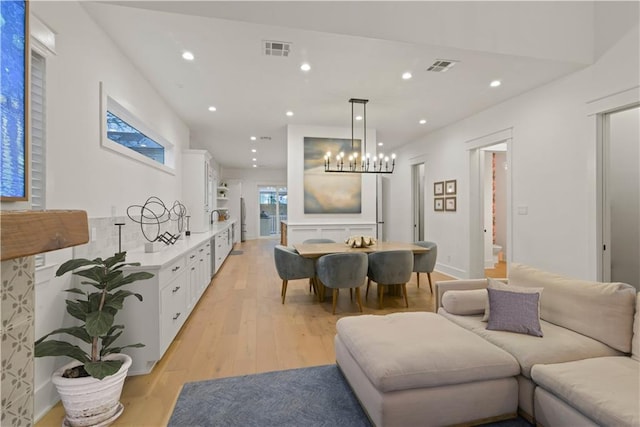 dining area with a notable chandelier and light hardwood / wood-style flooring