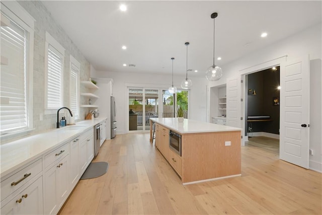 201 S Cortez St, New Orleans, LA 70119 - kitchen featuring appliances with stainless steel finishes, open shelves, a center island, light wood-style floors, and recessed lighting