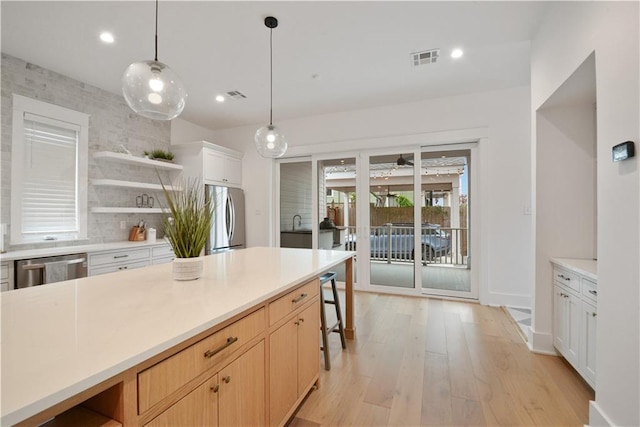 201 S Cortez St, New Orleans, LA 70119 - kitchen with appliances with stainless steel finishes, open shelves, light wood-style flooring, light countertops, and hanging light fixtures