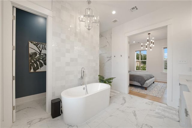 201 S Cortez St, New Orleans, LA 70119 - ensuite bathroom with a chandelier, marble look tile flooring, a soaking tub, vanity, and recessed lighting
