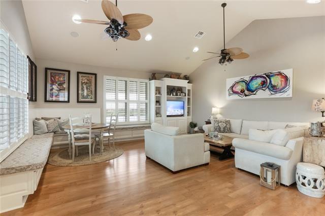 living room with a wealth of natural light, light hardwood / wood-style flooring, and vaulted ceiling